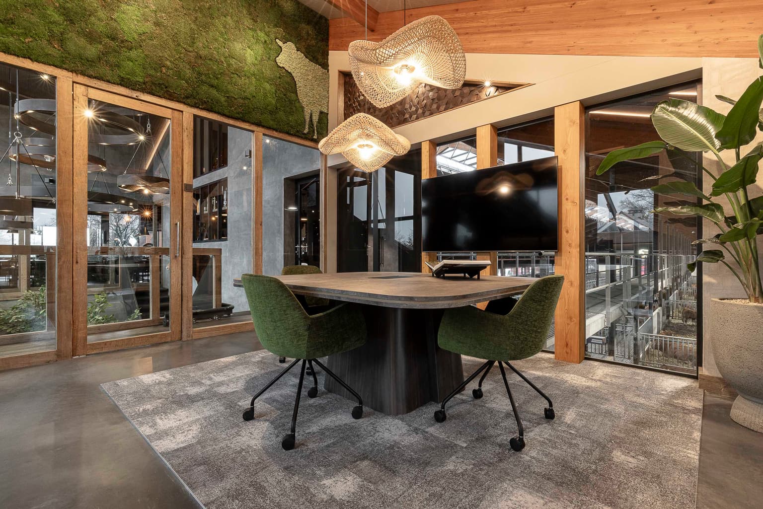 Vergaderruimte met vierkante vergadertafel en twee groene stoelen. 