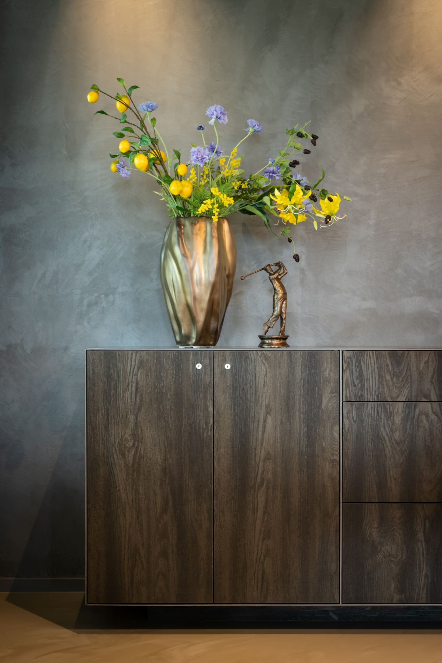 Gouden vaas op houten opbergkast. 