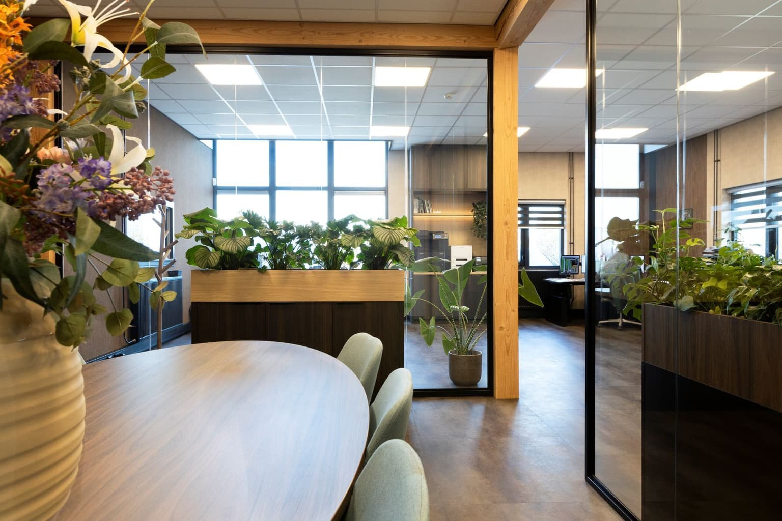 Glazen ruimte met vergadertafel erin. 