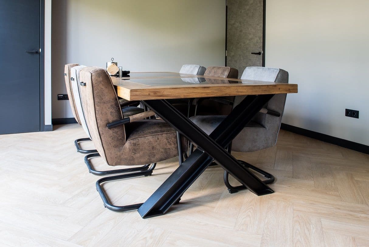 Stoere vergadertafel met zes leren stoelen eromheen. 