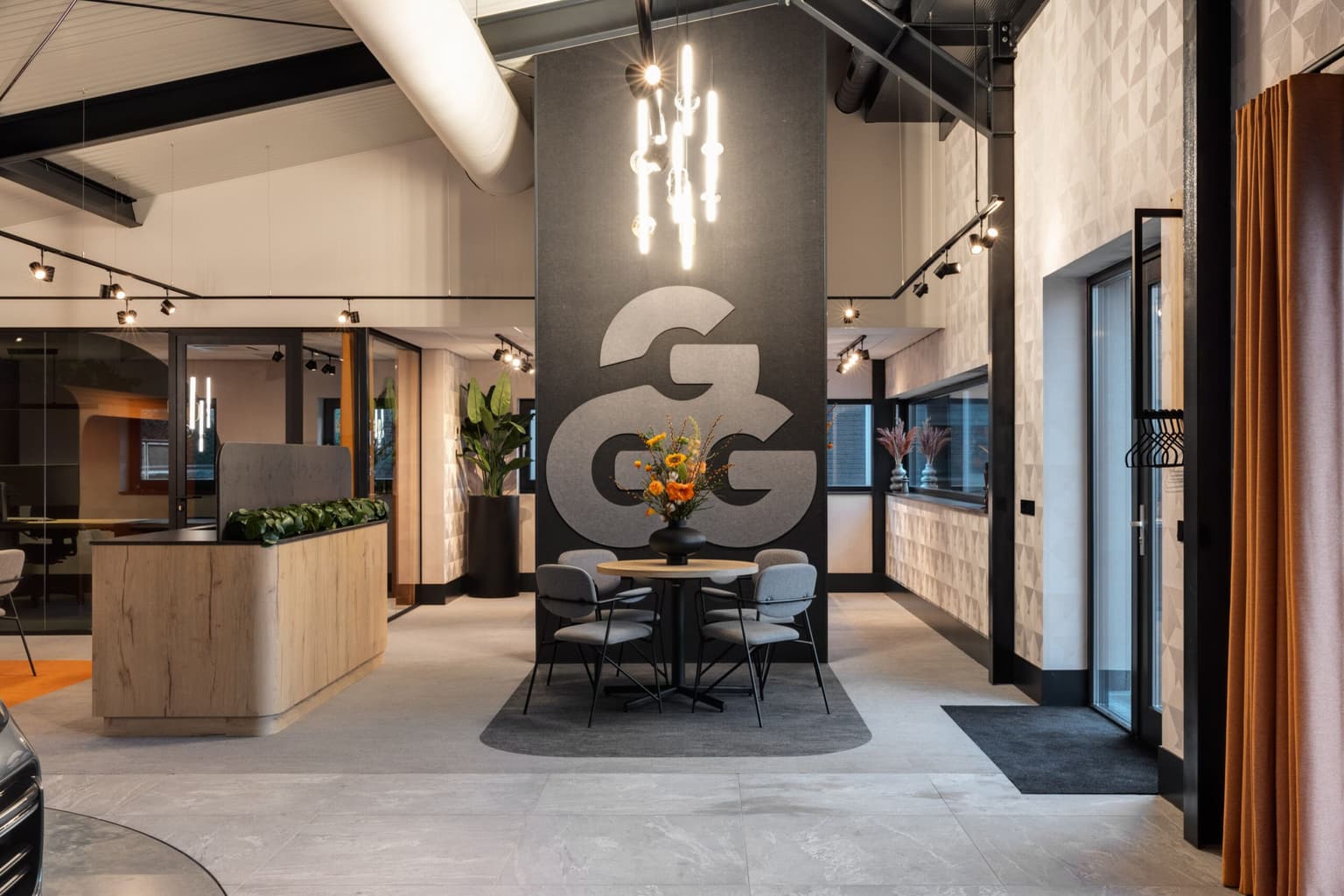 Entree van autoshowroom Garage Geurtsen met hun logo groot tegen een wand.