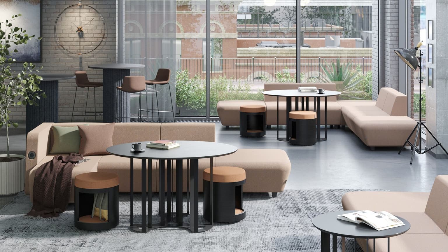 Zandkleurige banken met roze poefen erbij staan in een kantine.