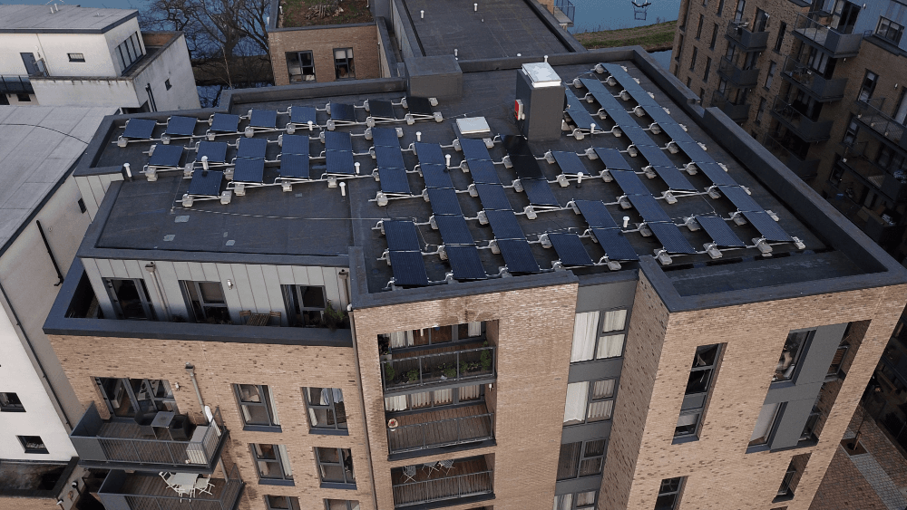 We zien het dak van een gebouw, dat volledig is volgebouwd met zonnepanelen. 